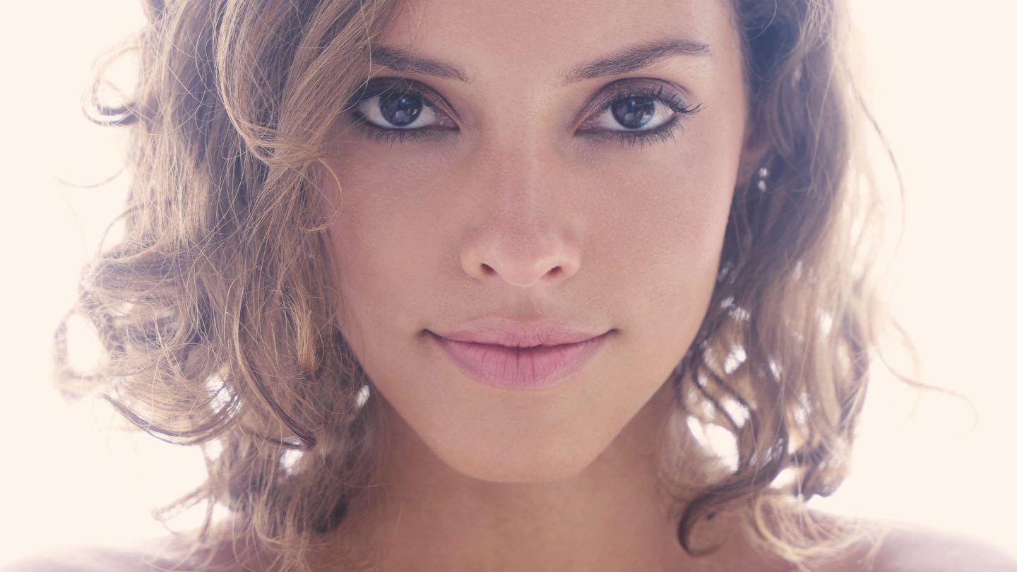 A woman with curly hair and fresh, hydrated-looking skin
