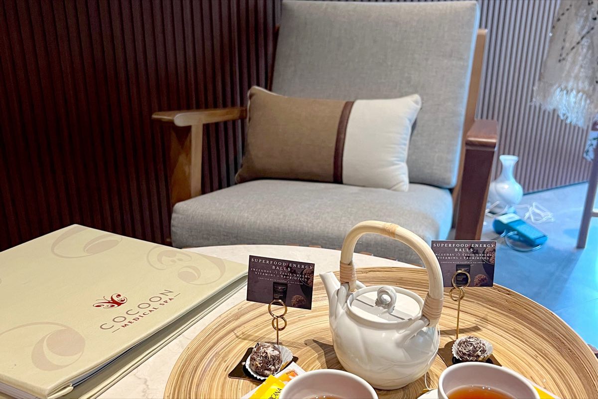 An armchair beside a tray of tea and a Cocoon menu, ready for a guest