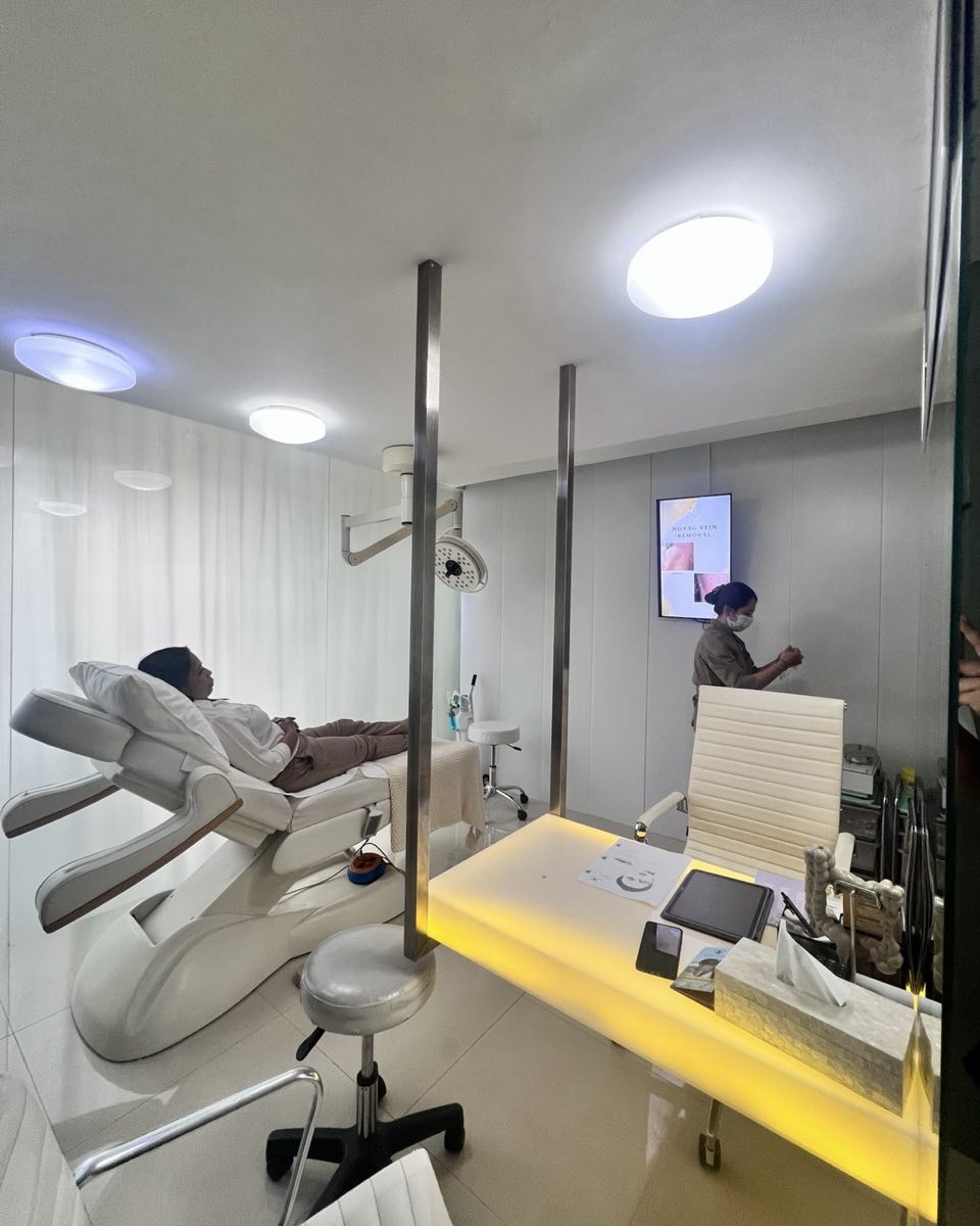 A Cocoon treatment room: a guest resting on the bed, the lit desk and a nurse at the door