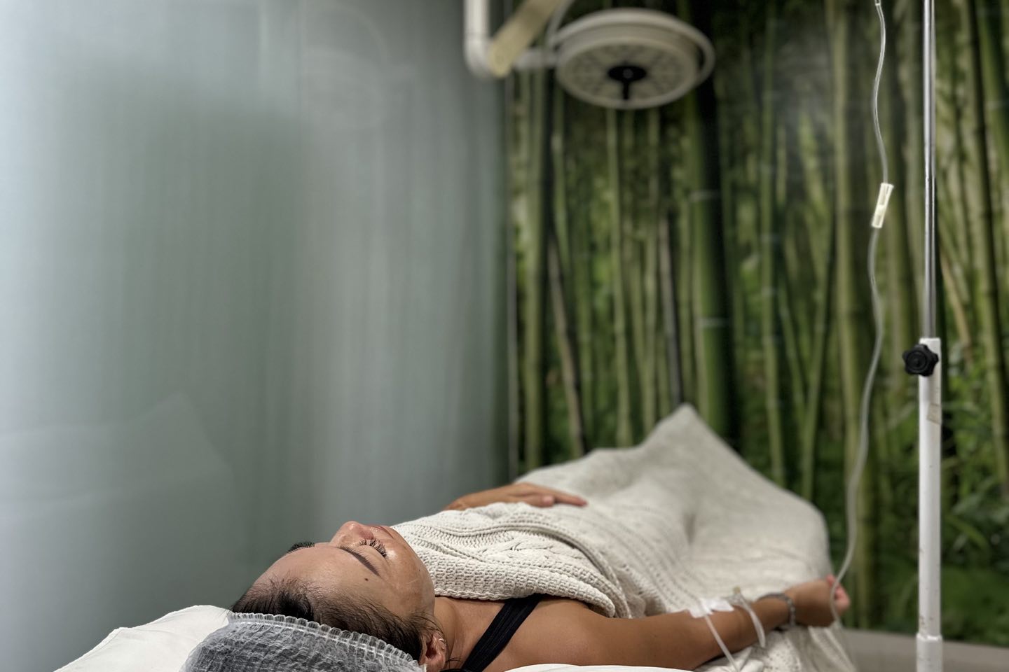 A guest resting while a vitamin drip runs, in the Legian drip lounge