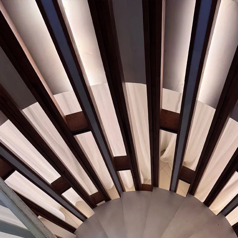 Looking up a spiral staircase of timber and light