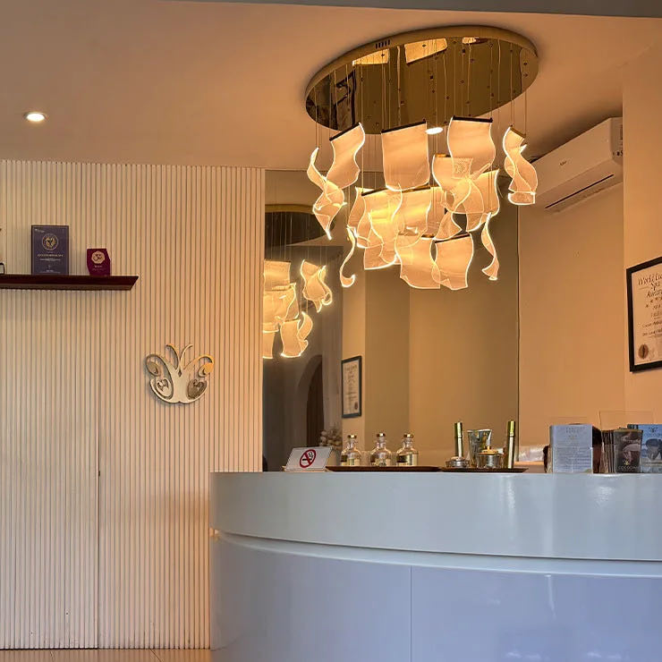 The Canggu reception: a curved white desk beneath a sculptural chandelier