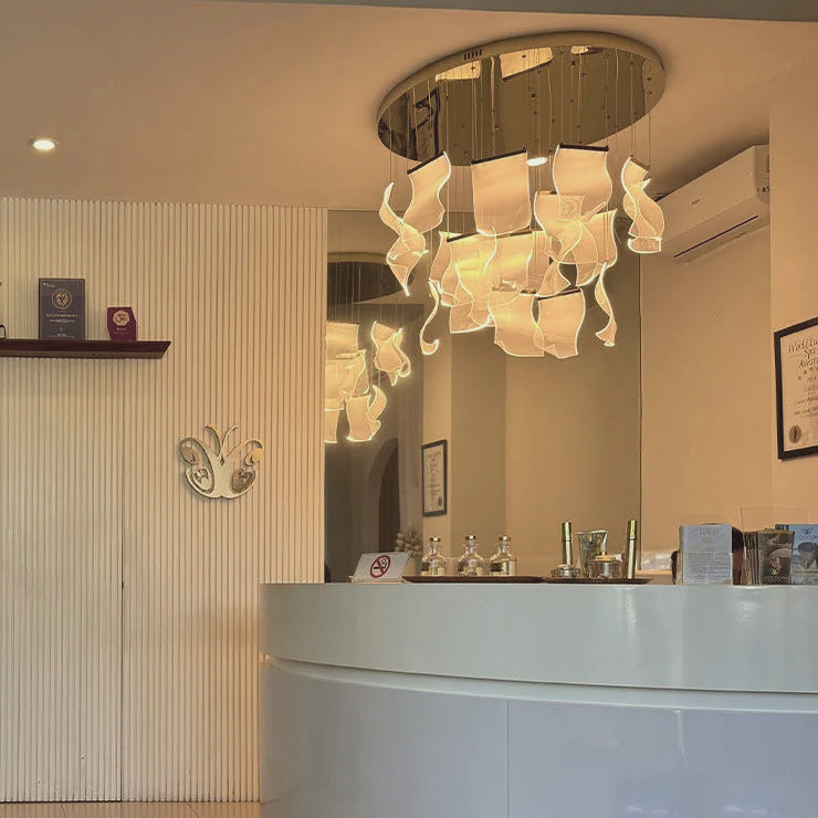 The Canggu reception: a curved white desk beneath a sculptural chandelier