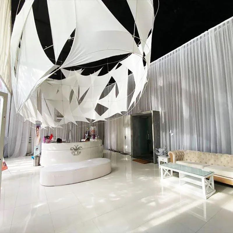The Legian reception: a curved white desk beneath a sculptural white ceiling installation