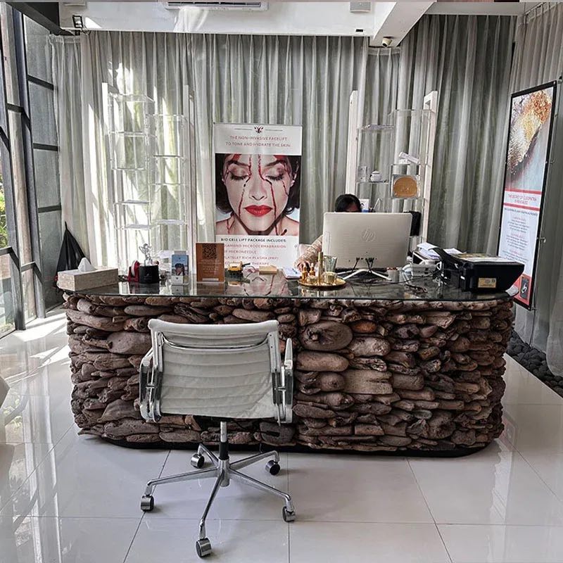 The Ubud reception: a river-stone desk with white leather chairs before tall curtains
