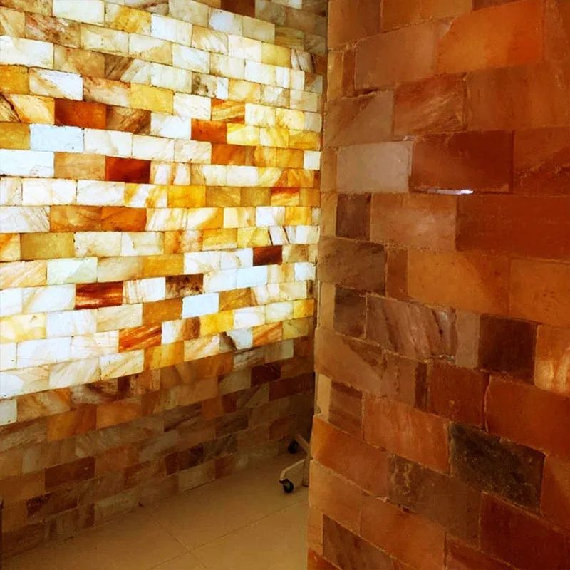 A backlit Himalayan salt-brick wall glowing amber and cream at Cocoon