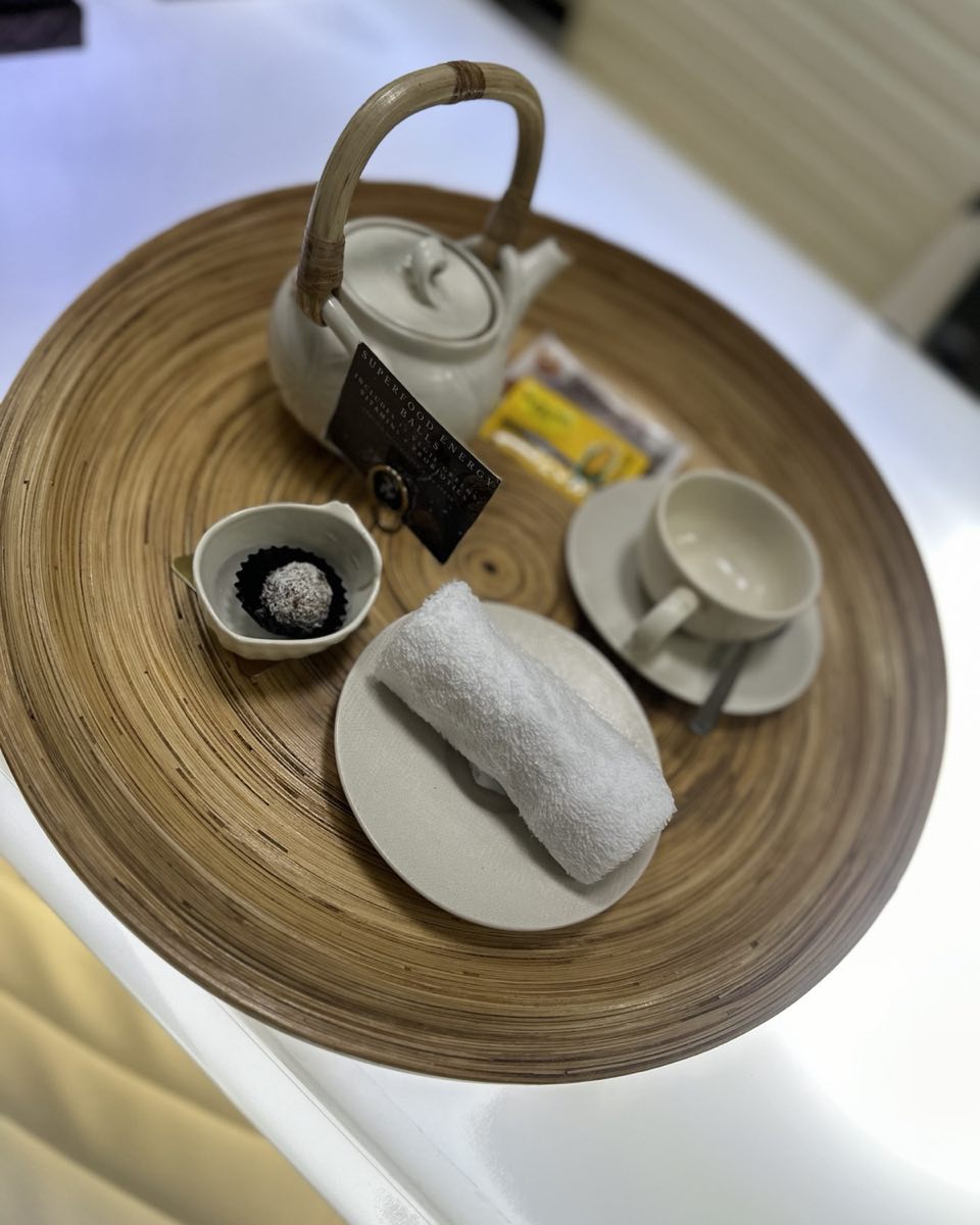A tea tray with a pot, a cup and a cool towel, set out for a guest